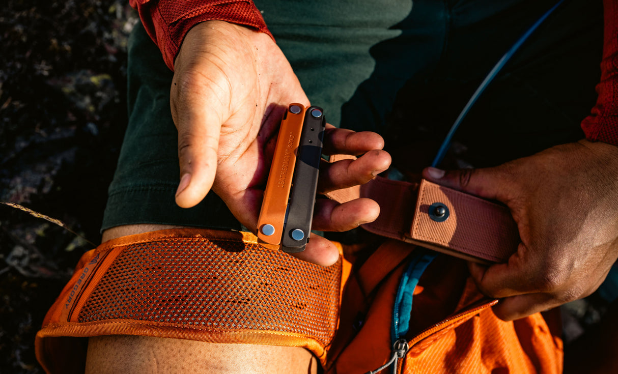 Translation missing: en.Person holding a closed Burnt Sienna bond in one hand and an open Sienna sheath in the other hand
