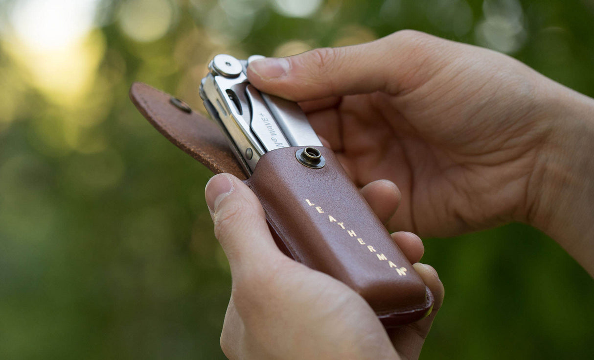 Translation missing: en.Man pulling Leatherman Wave+ out of Leatherman Heritage Sheath
