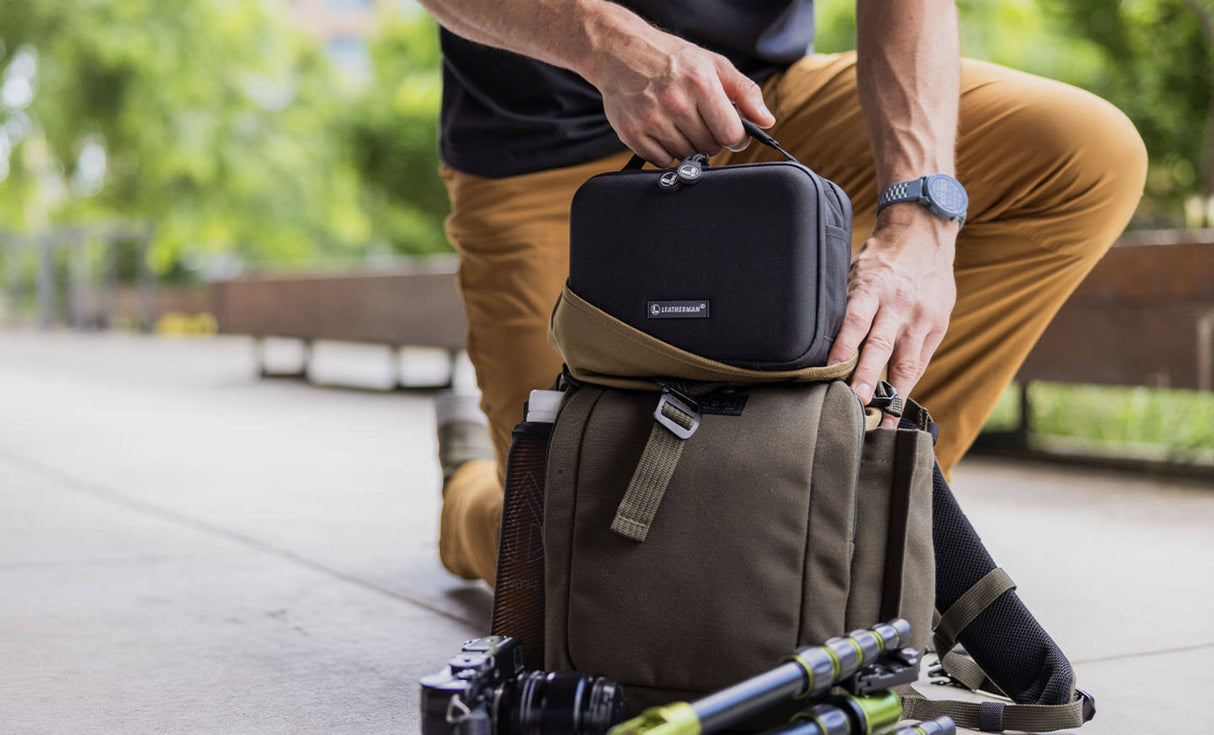 Translation missing: en.Man placing LeathermanĀ® Adapt Kit in crossbody bag