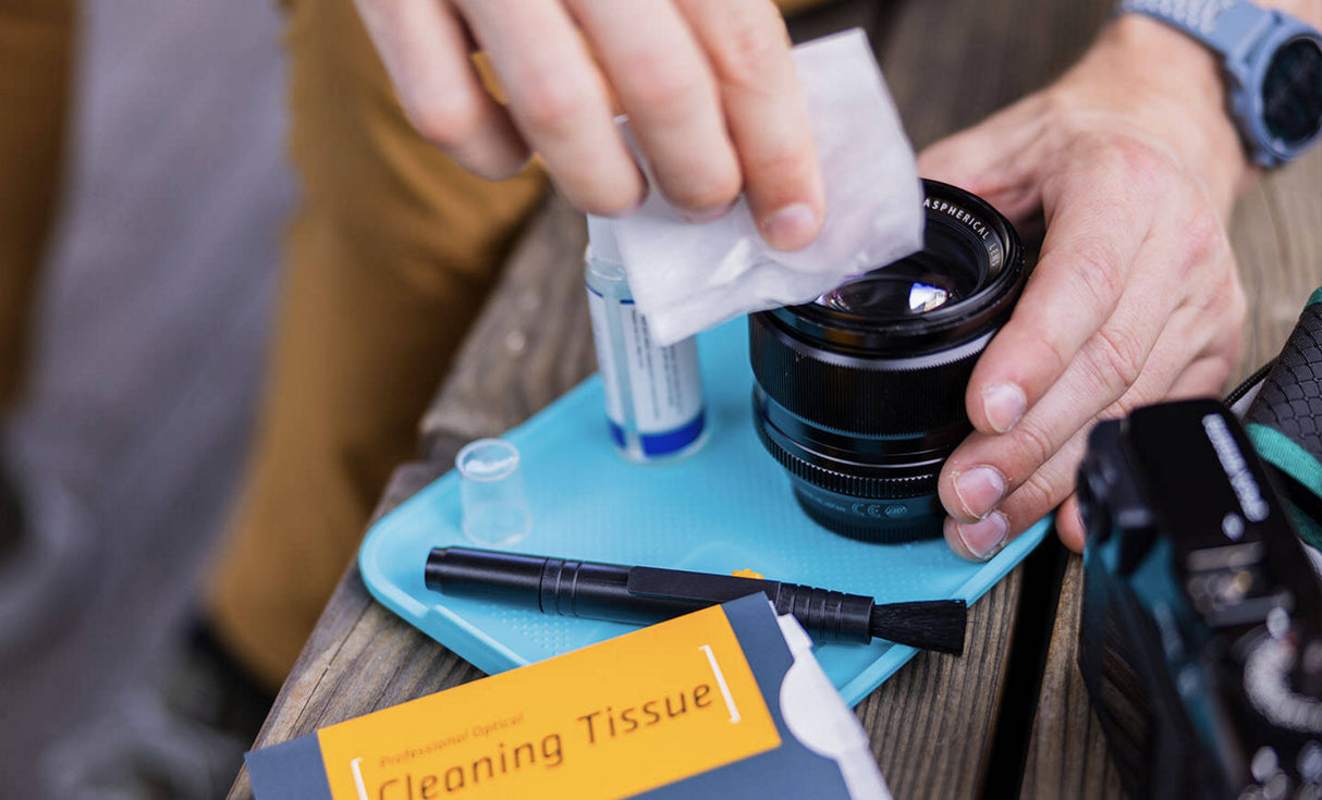 Translation missing: en.Man using LeathermanĀ® Adapt Kit tray to clean camera lens