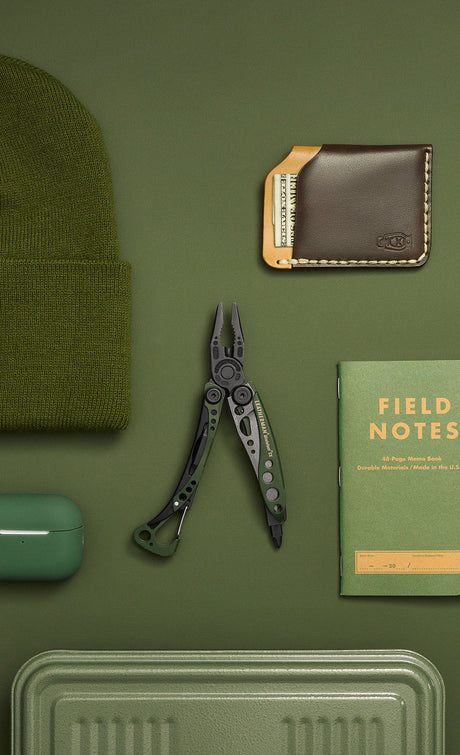 Translation missing: en.A green Skeletool CX open showing pliers laying on a green background surrounded by green objects