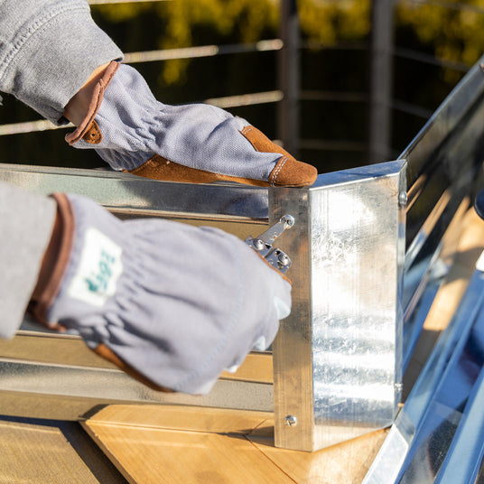 Translation missing: en.Someone using the screwdriver on a Leatherman Wingman to screw in the side of a flower bed