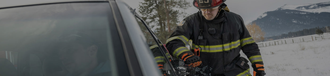 Translation missing: en.A firefighter stands beside a car, wearing protective gear and looking ready for action