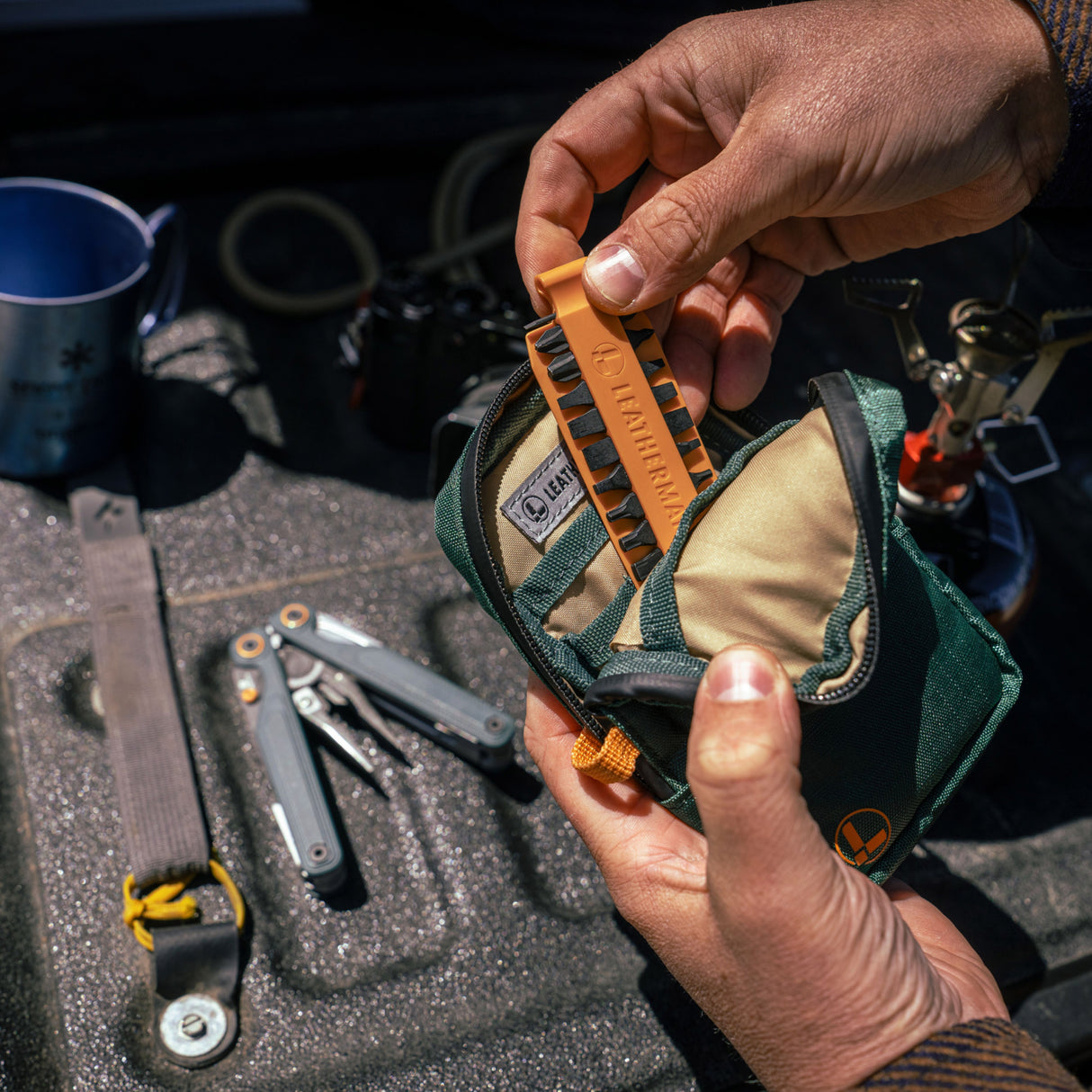Translation missing: en.A person placing Orange Leatherman Bit Kit into Tool Pouch