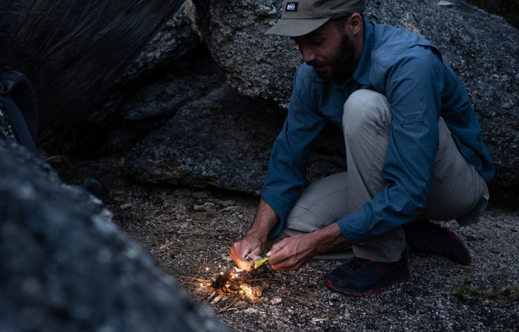 Man using Signal ferro rod to start fire