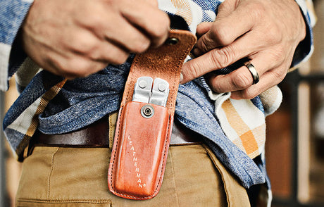 Leatherman Curl in a closed position on a table next to a wallet and a flashlight.