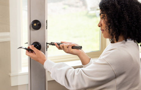 Person using a Leatherman screwdriver to add a number to the side of the house.