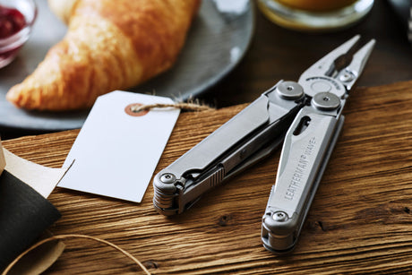 Leatherman Wave Plus open on a table next to a wrapped gift