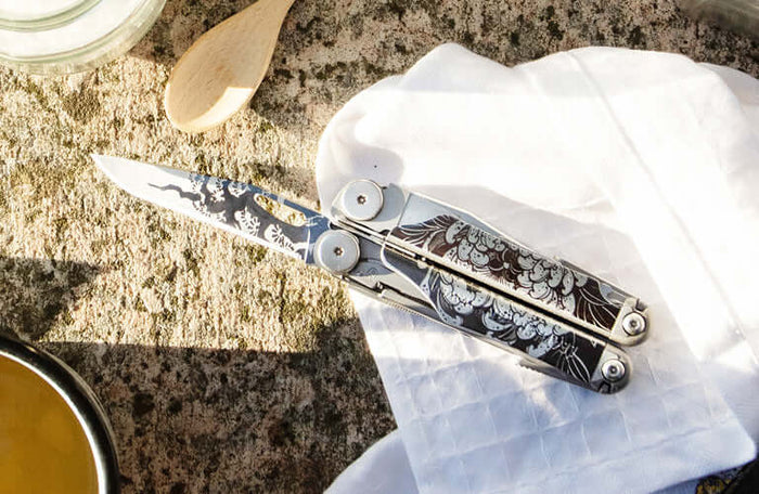 Translation missing: en.Wave® Plus multi-tool with intricate floral design on a stone surface surrounded by kitchenware