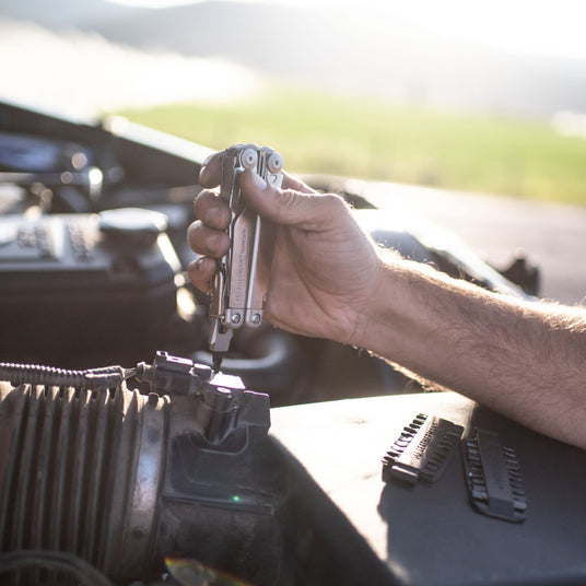 Leatherman Surge being used to work on a truck with a bit kit set