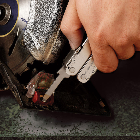 Someone using the medium screwdriver on a Leatherman Super Tool 300 to tighten something.