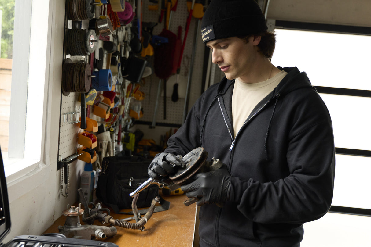 Translation missing: en.A person wearing a black Leatherman Vintage Beanie working on a car part in a garage