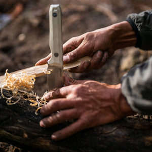 Translation missing: en.An individual carefully cutting wood with a Leatherman Alpine Pioneer knife, demonstrating craftsmanship and attention to detail