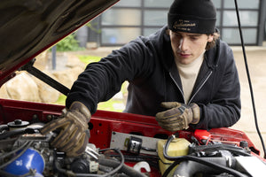 Translation missing: en.A person wearing a black Leatherman Vintage Beanie working under the hood of a red vehicle