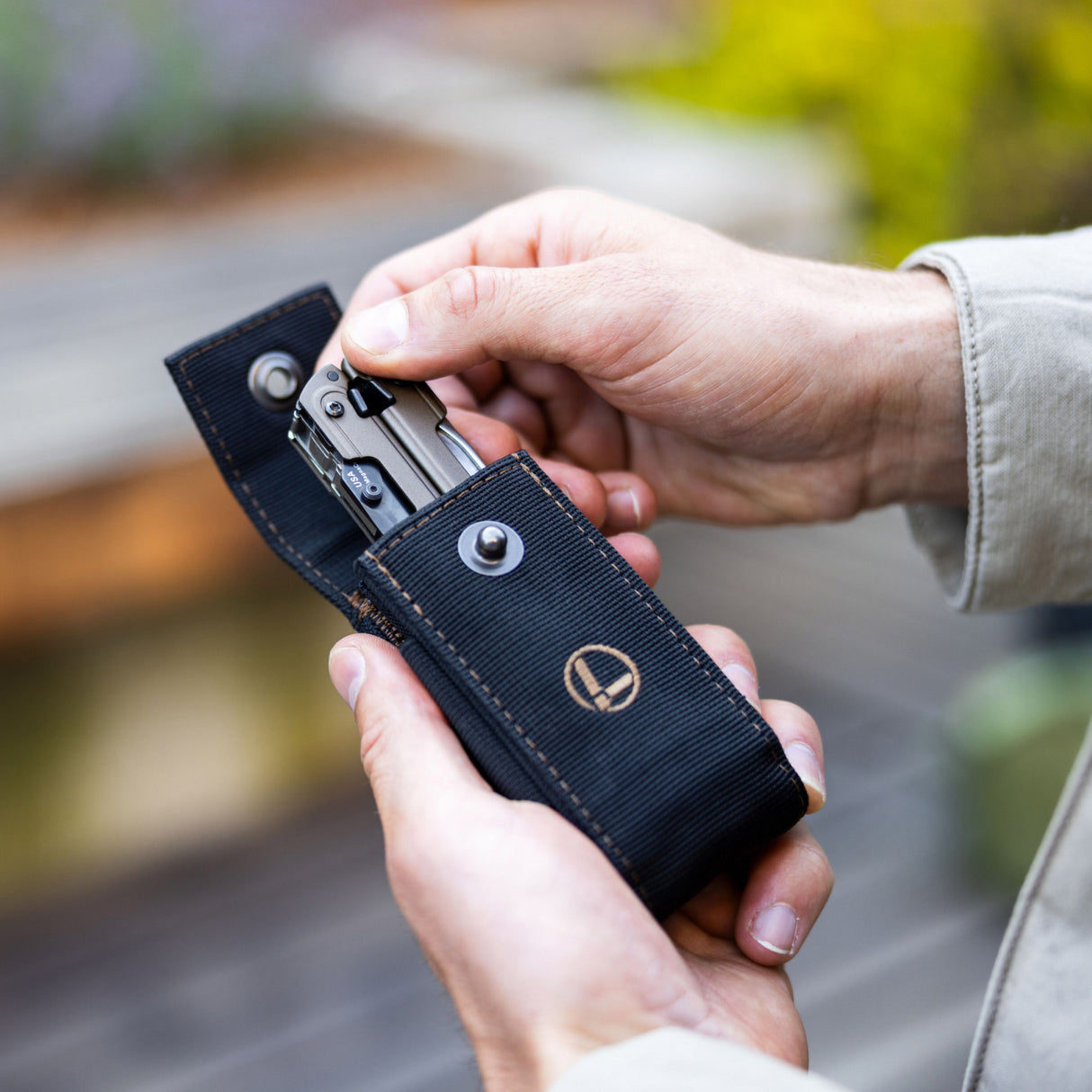 Translation missing: en.A hand pulls a Leatherman ARC Talos from a Black Bronze Nylon Sheath, showcasing how easy it is to access your multi-tool anytime you need it