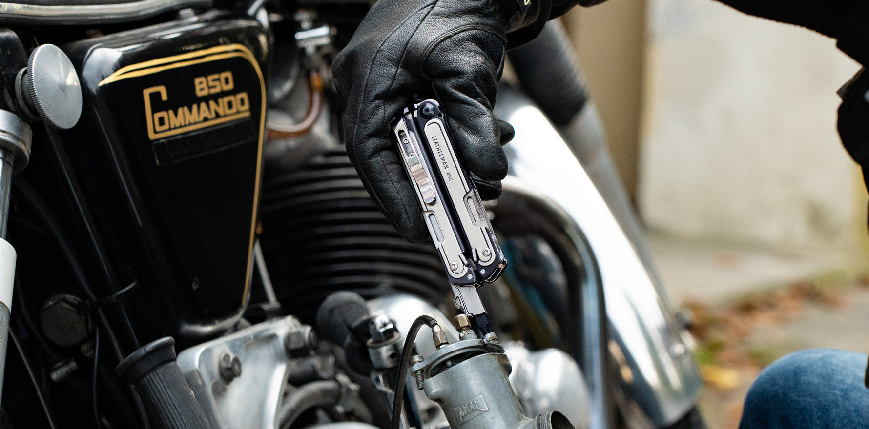 Leatherman ARC® multi‑tool being used to adjust a motorcycle component.