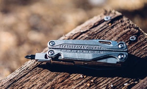 Translation missing: en.Leatherman Charge+ TTI laying on piece of wood under sunlight