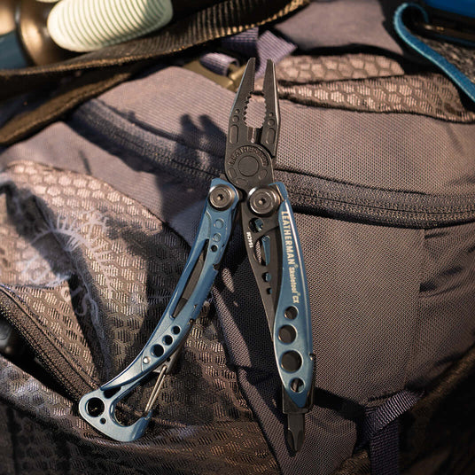 Translation missing: en.Nocturnal Leatherman Skeletool® Cx multi-tool displayed on a backpack, showcasing its sleek design and functionality
