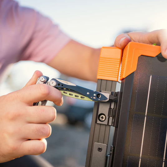 Person using nightshade Leatherman Skeletool Cx screwdriver to tighten screw on solar panel. 