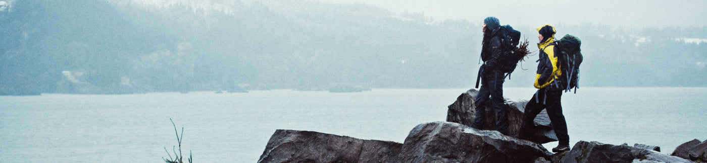 Two mountain hikers looking at lake. 