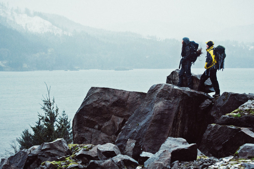 Two mountain hikers looking at lake. 