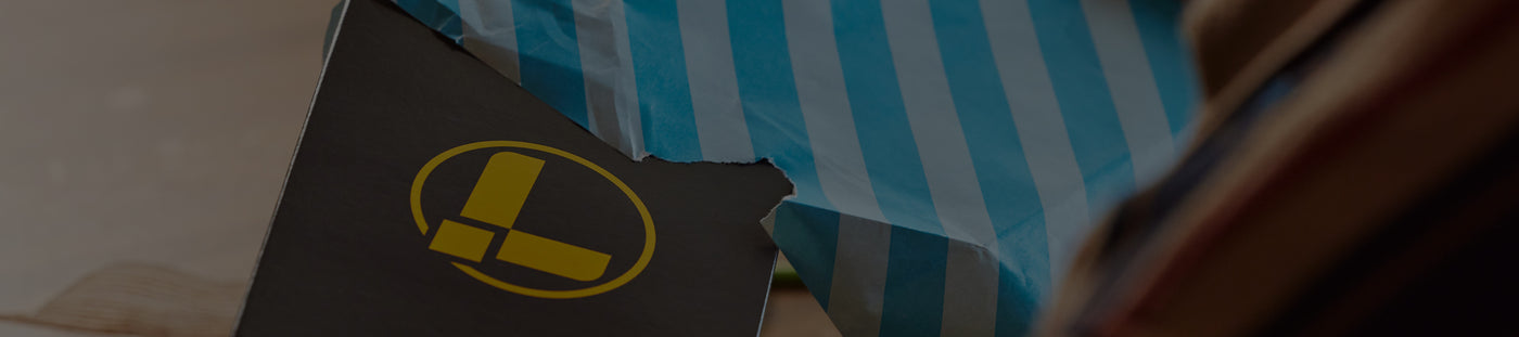 Translation missing: en.A man unwraps a present containing a Leatherman box