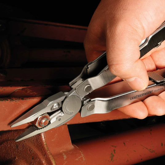 Person using Leatherman Super Tool 300 pliers to tighten bolt nut. 