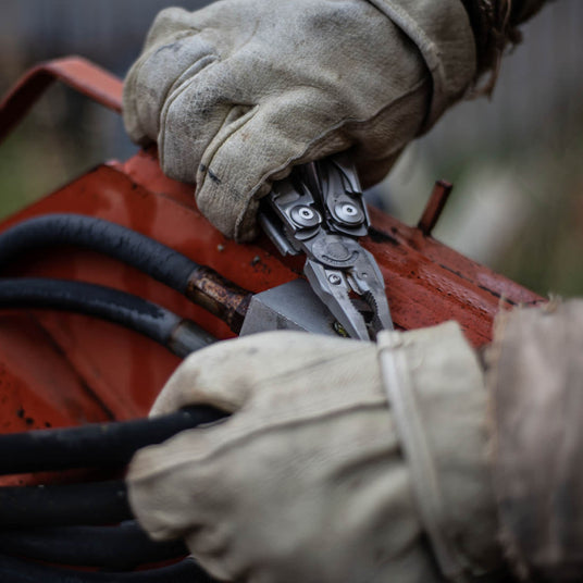 Person using Leatherman Surge pliers to tighten bolt nut. 