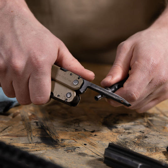 Person using Leatherman Coyote tan Super Tool 300m carbon scraper. 