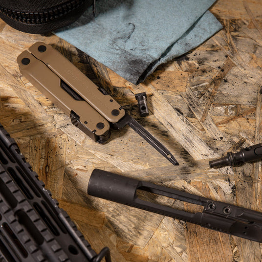 Leatherman coyote tan Super Tool 300m with carbon scraper on workshop table. 