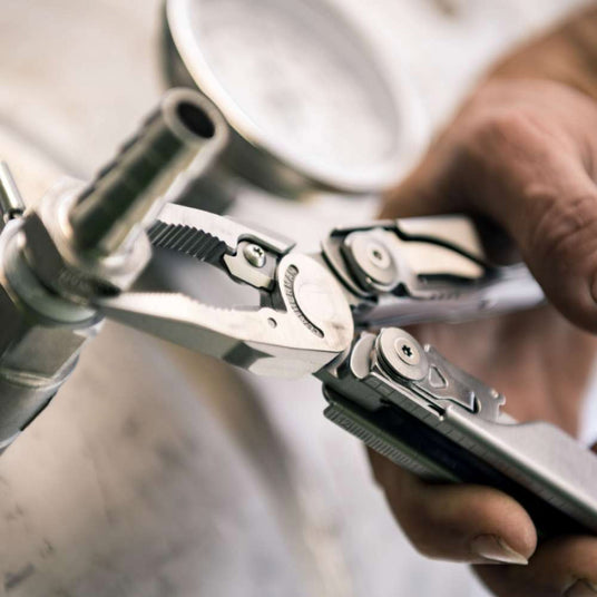 Person using Leatherman Surge pliers to tighten bolt nut. 