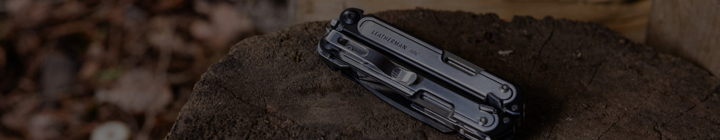 Leatherman Arc rests on a wooden surface, showcasing its sleek design against the natural texture of the wood.