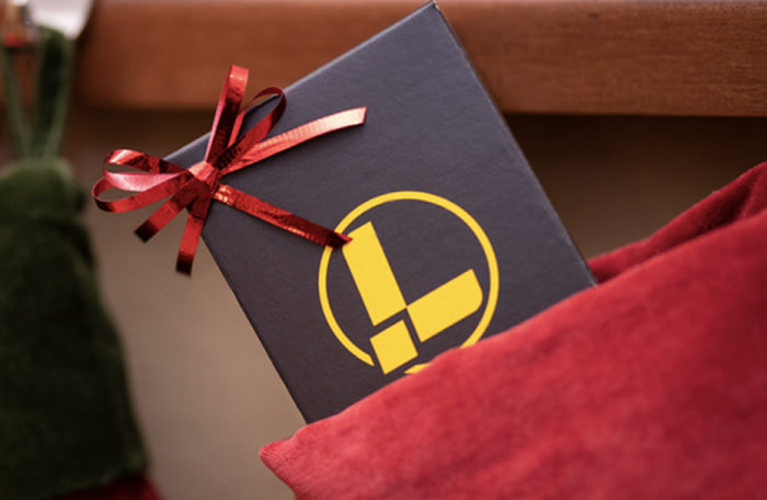 Translation missing: en.A festive Christmas stocking filled with a Leatherman gift box wrapped in bright red ribbon, ready for holiday celebrations