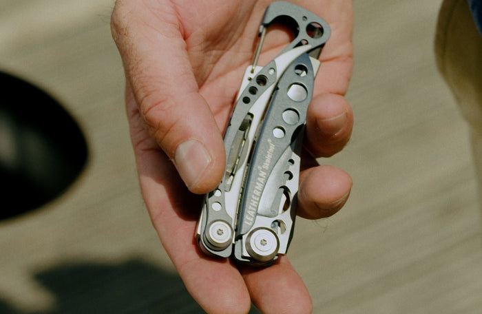 Translation missing: en.A person holding a Leatherman Skeletool® multi-tool in hand, showcasing its sleek metallic design