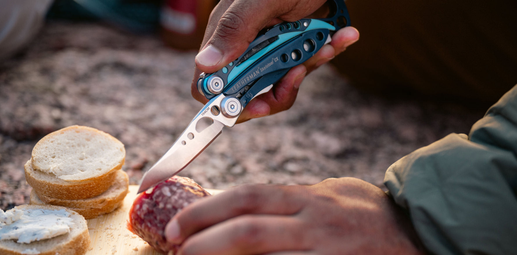 Skeletool CX blade cutting slice of summer sausage