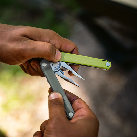 A hand firmly holds Leatherman bond, highlighting its distinctive colors and design features.